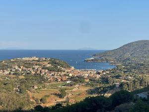 a town on a hill with the ocean in the background at Aria di Collina - Isola d'Elba in Porto Azzurro