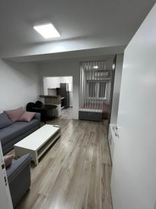 een woonkamer met een bank en een tafel bij Stefanoski Apartments in Skopje