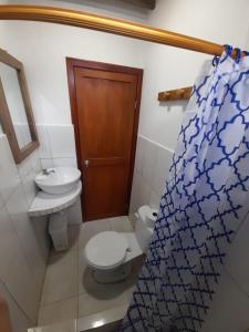 ein Bad mit einem WC und einem Waschbecken in der Unterkunft Hostal SoleMare in Montañita