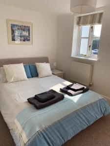 a bedroom with a bed with two towels on it at Waters Reach in Abersoch +9 photos