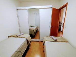 um pequeno quarto com duas camas e um espelho em APTO, 2/4, 2 ar-condicionados e bem localizado. em Palmas mais 8 fotografias