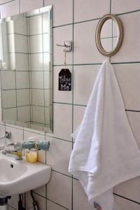 La salle de bains est pourvue d'une serviette blanche suspendue à un miroir. dans l'établissement M home place, à Palio Limani