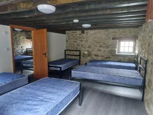 a room with three beds and a window at Cwm Clyd Longhouse in Llanwrthwl