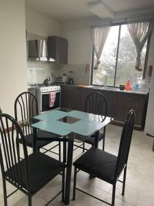 a kitchen with a table and chairs in a kitchen at Lujoso depto. en ”Torre Nur” in Cochabamba
