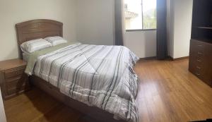 a bedroom with a bed and a wooden floor at Lujoso depto. en ”Torre Nur” in Cochabamba