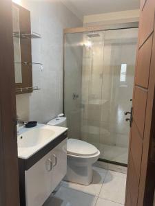 uma casa de banho com um WC e uma cabina de duche em vidro. em Lujoso depto. en ”Torre Nur” em Cochabamba