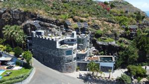 une vue aérienne sur un bâtiment situé sur le côté d'une montagne dans l'établissement Castelo do Mar, Madeira, à Tábua