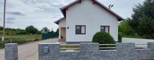mały biały dom z kamienną ścianą w obiekcie kuća za odmor Domus Alba w mieście Branjin Vrh