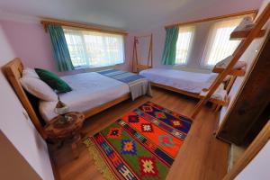 a bedroom with two bunk beds and a rug at Alphan Cappadocia in Uchisar