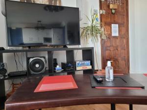 ein Wohnzimmer mit einem Tisch und einem TV darüber in der Unterkunft Apartamento Santa Cruz de Tenerife - Bien situado en zona comercial - Buenas conexiones in Santa Cruz de Tenerife