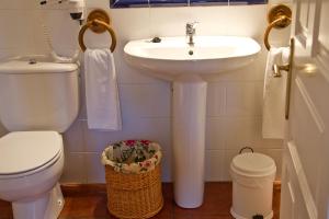 a white bathroom with a sink and a toilet at Hotel Casona El Arral in Liérganes +64 photos
