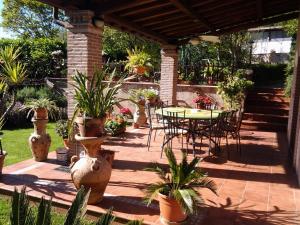 un patio con mesas, sillas y macetas en Casa del Girasole, en Genazzano