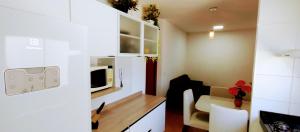 a small room with a kitchen and a microwave at APTO, 2 quartos, confortável e bem localizado in Palmas