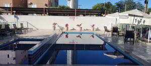 a swimming pool with a table and chairs in a building at APTO, 2 quartos, confortável e bem localizado in Palmas