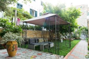 a gazebo with a couch in a garden at B&B Villa Dubrovnik Garden in Dubrovnik