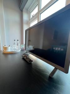 un monitor de ordenador sentado en un escritorio con mando a distancia en The Six Bells en Newbury