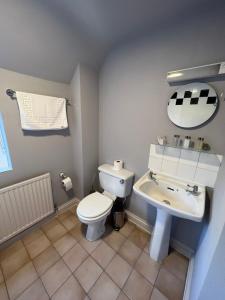 a bathroom with a white toilet and a sink at The Six Bells in Newbury