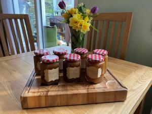 a group of four jars of honey on a wooden table at Montague Villa in Dunoon