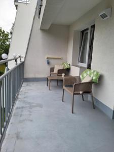 米茲多洛傑的住宿－REZYDENCJA BIELIK，大楼内的阳台配有两把椅子和一张桌子