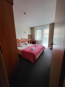 a bedroom with a bed with a pink blanket at REZYDENCJA BIELIK in Międzyzdroje