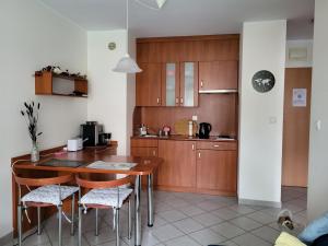 a kitchen with wooden cabinets and a table and chairs at REZYDENCJA BIELIK in Międzyzdroje +7 photos