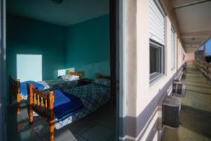 two beds in a room with green walls at Pousada Guarida in Rio Grande