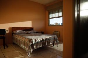 a bedroom with a bed and a window at Pousada Guarida in Rio Grande