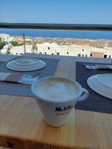 una taza de café en una mesa con platos en Grande Murano, en Fira