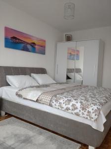 um quarto com uma cama grande e uma pintura grande na parede em Apartman Nova Varos em Banja Luka
