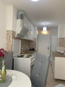 uma cozinha com um fogão branco forno superior ao lado de uma mesa em Apartman Nova Varos em Banja Luka