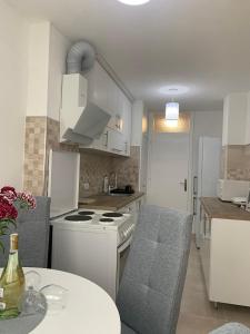 a kitchen with a white stove top oven next to a table at Apartman Nova Varos in Banja Luka +14 photos