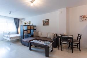 ソフィアにあるKarastoyanovi's Apartmentのソファとテーブルのあるリビングルーム