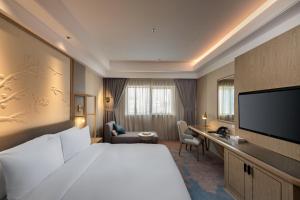 a hotel room with a large bed and a flat screen tv at Aber Bani Amr in Al Namas