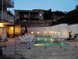 a swimming pool with chairs and a house at Apartments Horizont Mostar in Mostar