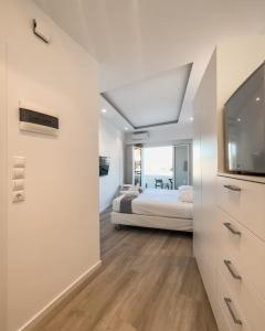 1 dormitorio con 1 cama y TV en una habitación en TIKI BEACH STUDIOS, en Nea Makri