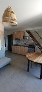 a living room with a table and a kitchen at Maison 1862 - Hébergements d'hôte in Orsan