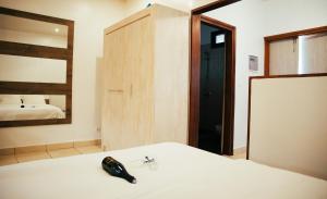 ein Schlafzimmer mit einem Bett, einem Spiegel und einem Telefon in der Unterkunft Garden Apartment Abidjan in Abidjan