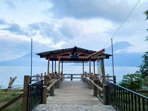 a wooden boardwalk leading to the ocean on a beach at Unicorn Reborn - Peaceful Rentals in San Marcos La Laguna