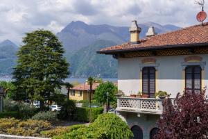 ein Haus mit Balkon und Bergen im Hintergrund in der Unterkunft Casa Aidee in Varenna