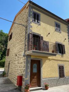 um edifício de tijolos amarelos com uma varanda e uma porta em Il Gaudente B&B em Santa Fiora