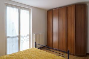 1 dormitorio con 1 cama y armario de madera en Casa Aidee, en Varenna