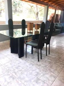 a glass table with black chairs and a couch at Mediterranean Escape in Flogita