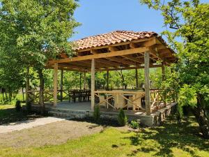 a wooden gazebo with a table in a field at Nazy's Guest House in Joqolo