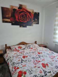 a bedroom with a bed with red flowers on it at OAZA in Mokra Gora