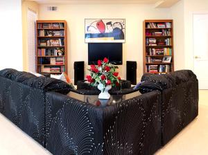 a black leather couch in a living room with a table at Little Paradise with Sauna Garden near Downtown in Saratoga