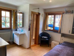 uma pequena casa de banho com um lavatório e uma cama em Chalet Medi em Zermatt