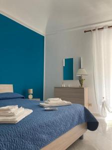 - une chambre bleue avec un lit et une couverture bleue dans l'établissement Sofi House, à Santo Stefano di Camastra