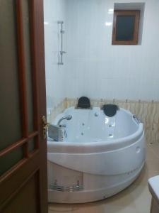 a white bath tub in a bathroom next to a door at D&G guest house in Yeghegnadzor
