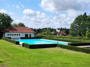 een groot zwembad in een tuin met een huis bij Zámek Lnáře in Lnáře