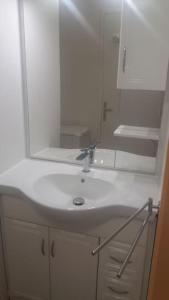 a bathroom with a white sink and a mirror at Studio Le Balisier in Caritan +10 photos